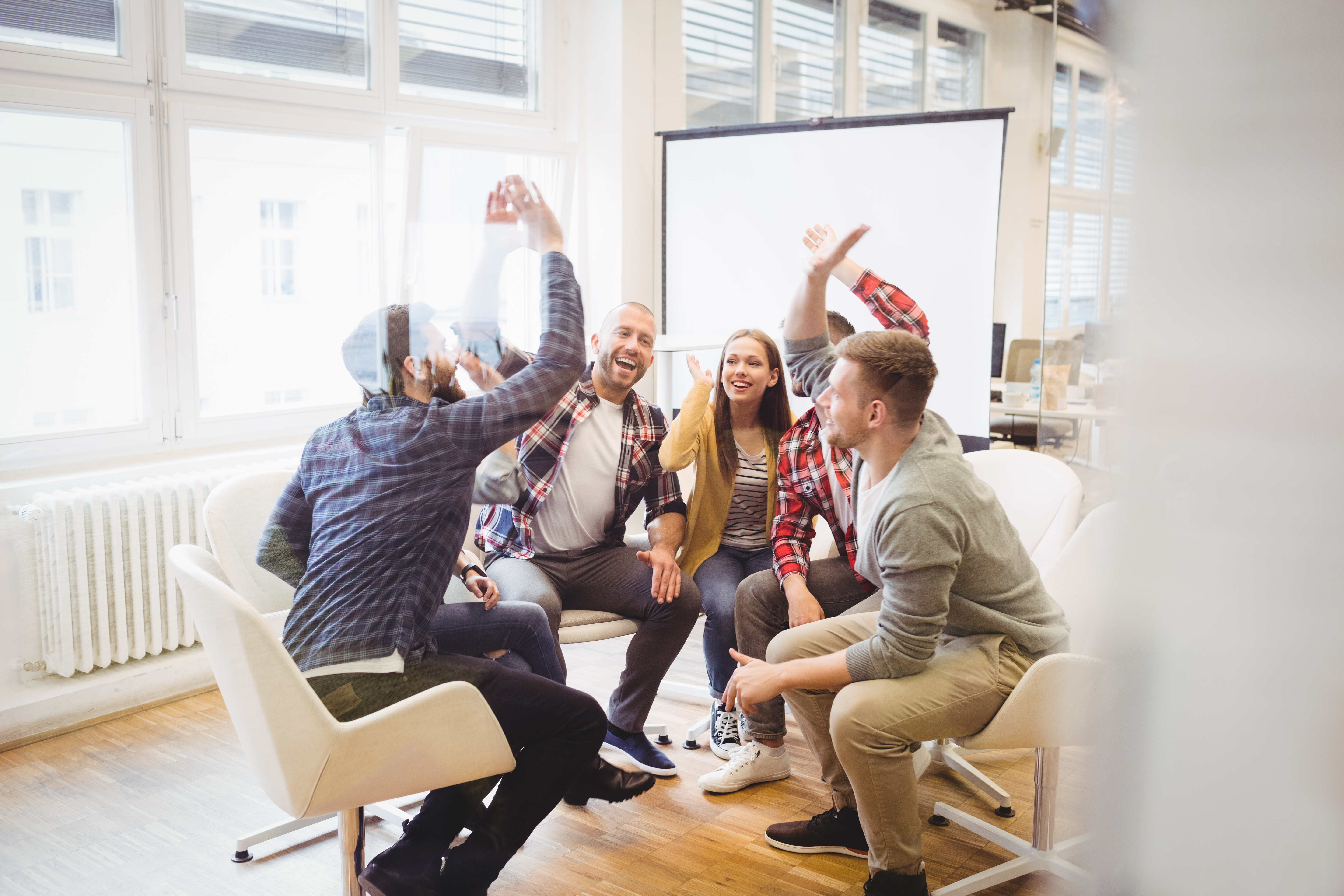 Excited creative business people giving high-five in meeting room at c